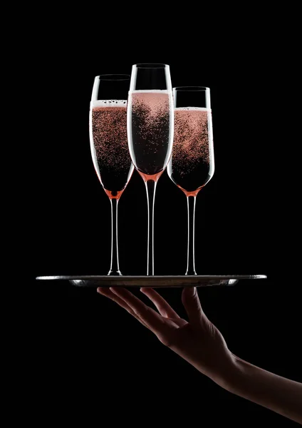 Ruka drží tác s brýlemi růžové rosechampagne — Stock fotografie