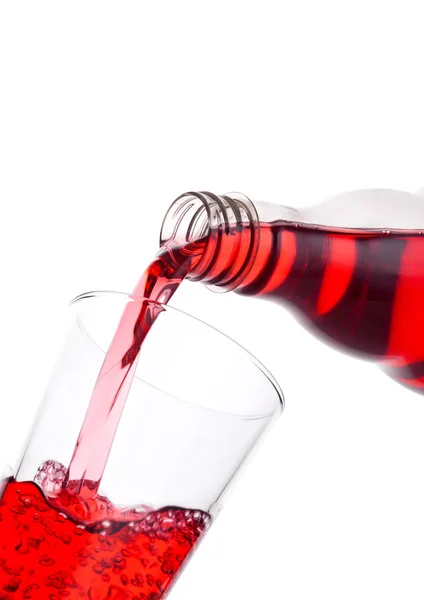 Verser le jus rouge de canneberge de la bouteille au verre — Photo