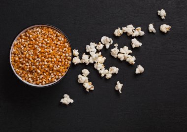 Siyah ham Mısır ve patlamış mısır ahşap üzerine bir kase