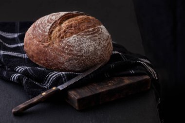 Mutfak havlusu ve bıçak ile taze pişmiş ekmek