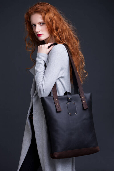 Рыжая модель с большой кожаной сумкой
 