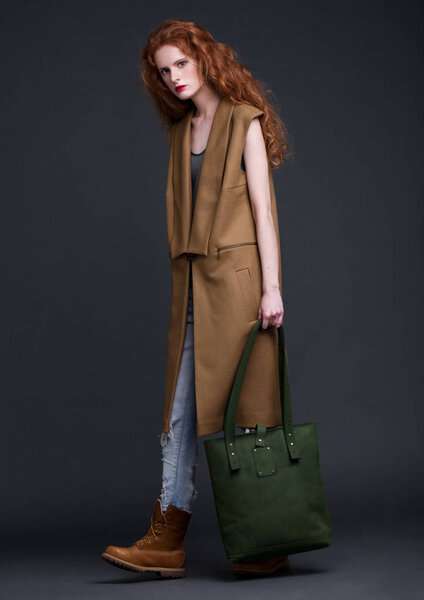 Рыжая модель с большой кожаной сумкой
 