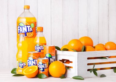 Londra, İngiltere - 31 Mart 2018: Plastik şişe ve Fanta portakal alkolsüz içecek Beyaz ahşap zemin üzerinde alüminyum teneke 