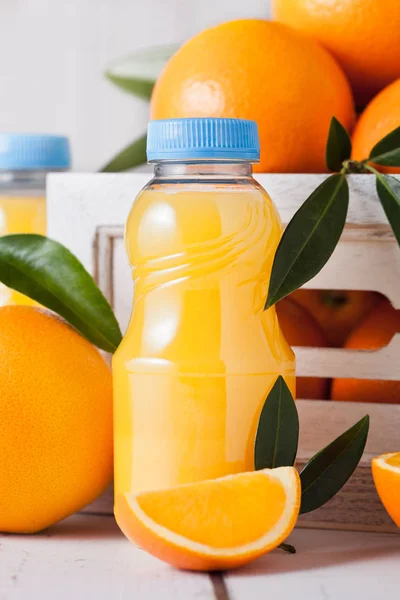 Botellas de plástico de zumo de naranja fresco orgánico crudo — Foto de Stock