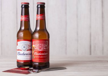 Londra, İngiltere - 27 Nisan 2018: Cam Budweiser bira şişesi şişe açacağı ile ahşap arka plan üzerinde.