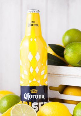 Londra, İngiltere - 27 Nisan 2018: Çelik şişe Corona ilave bira günbatımı Editionon ahşap arka plan ile taze limon ve limes ahşap kutusunda.