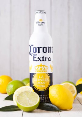 Londra, İngiltere - 27 Nisan 2018: Çelik şişe, Corona ilave bira taze limon ve limes ahşap zemin üzerine.