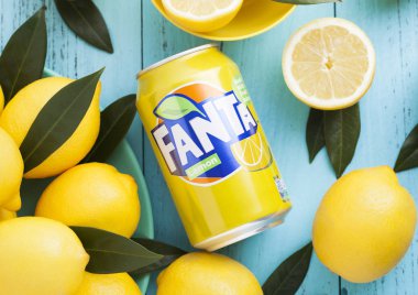 Londra, İngiltere - 27 Nisan 2018: Alüminyum Fanta Lemon meşrubat mavi ahşap zemin üzerine taze limon ile olabilir. Fanta popüler Meyve aromalı gazlı Coca-Cola şirketi tarafından oluşturulan meşrubat olduğunu.