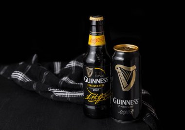 Londra, İngiltere - 27 Nisan 2018: Guinness fıçı şişman bira şişe koyu ahşap arka plan şişe ve alüminyum kutu.