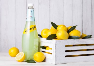 Londra, İngiltere - 27 Nisan 2018: Schweppes şişe limon suyu köpüklü İçecek taze limon ile ahşap arka plan üzerinde.