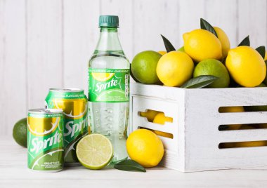 Londra, İngiltere - 12 Nisan 2017: Şişe ve alüminyum kutu Sprite içki limon ve limes ahşap zemin üzerine. Sprite limon benzeri aromalı içecek Coca Cola Company tarafından üretilen olduğunu.