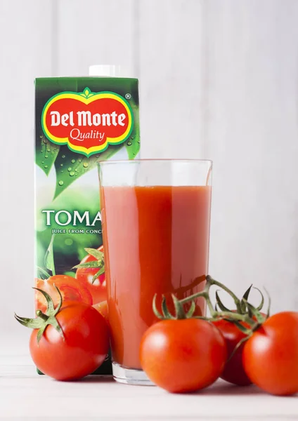 London, Storbritannien - 27 April 2018: Pack av Del Monte tomatjuice på trä bakgrund med glas och färska tomater. — Stockfoto