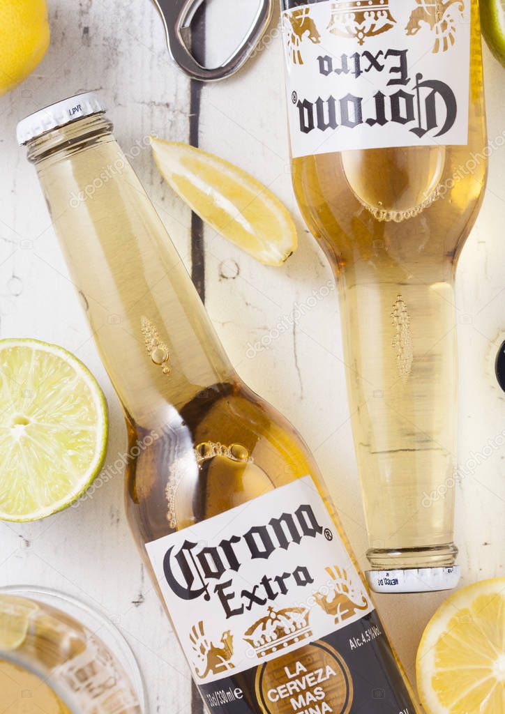LONDON, UK - APRIL 27, 2018: Glass Bottles of Corona Extra Beer on wooden background with bottle opener. Corona, produced by Grupo Modelo.
