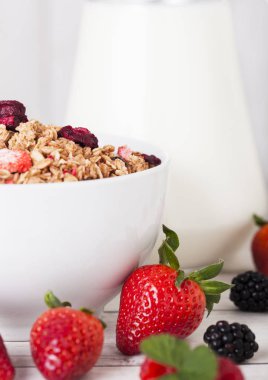 Tahıl ve taze meyveleri ve kavanoz süt ile kase