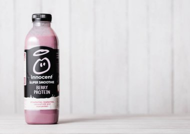 Londra, İngiltere - 03 Mayıs 2018: Şişe masum çilek smoothie meyve içkiyle vitaminler ahşap arka plan üzerinde.