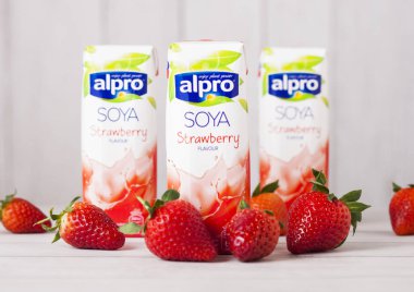 Londra, İngiltere - 03 Mayıs 2018: Pack Alpro Soya çilekli süt İçecek taze meyve ile ahşap arka plan üzerinde.