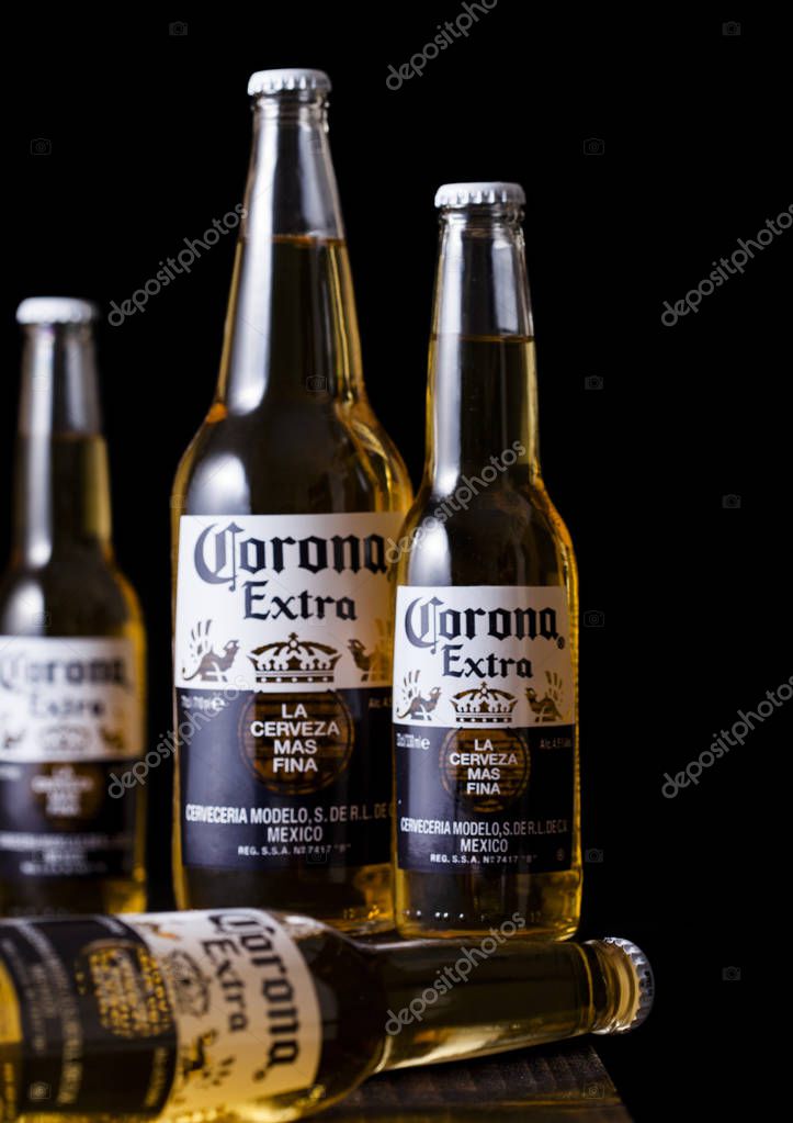 LONDON, UK - MAY 03, 2018: Bottles of Corona Extra Beer on wooden barrel and dark background.Corona, produced by Grupo Modelo.