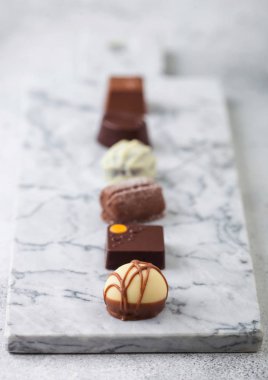 Lükslü çikolatalı şekerleme seçimi. Beyaz, koyu ve sütlü çikolata çeşitleri.