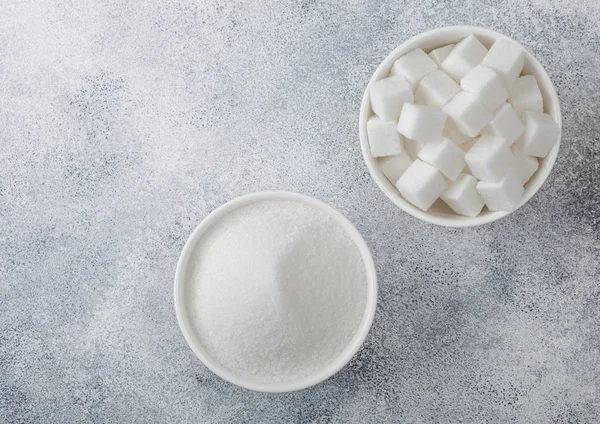 Witte schaal platen van natuurlijke witte suiker kubussen en geraffineerde suiker op lichte tafel achtergrond. — Stockfoto