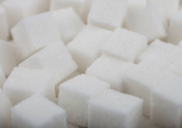 Close-Up shot of natural white sugar cubes on white background.