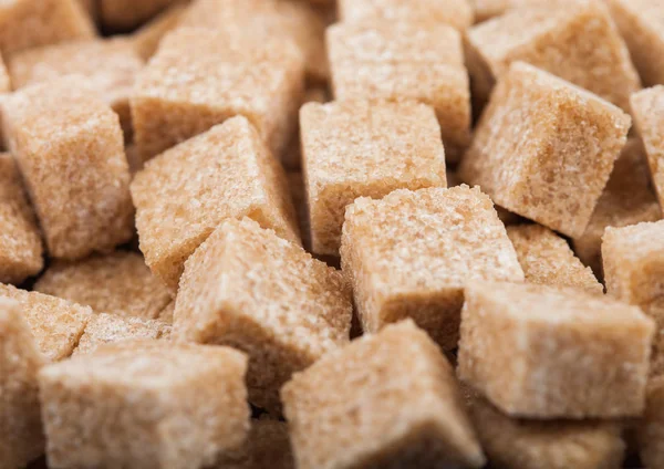 Close-Up tiro de cubos de açúcar mascavo natural no fundo branco . — Fotografia de Stock