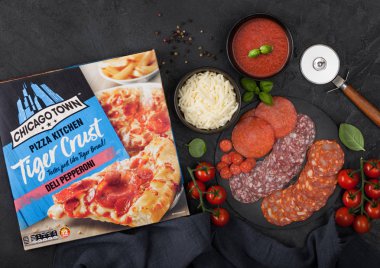 Londra, Uk - 20 Kasım 2019: Chicago şehri Tiger Crust Deli Pepperoni pizzası, siyah mutfak arka planında salam, peynir ve domatesli. 