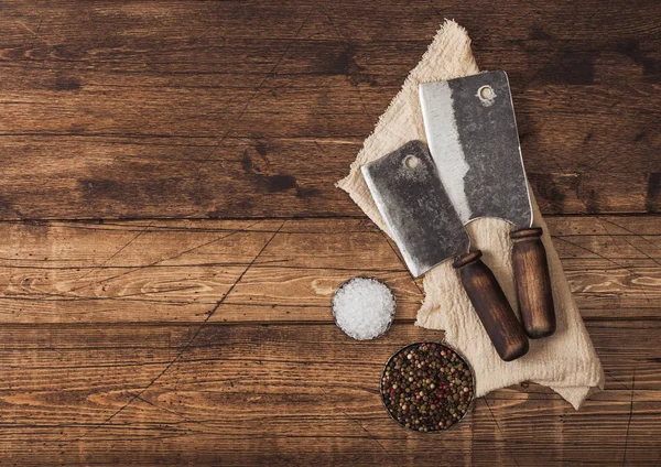 Hachettes vintage pour viande avec sel et poivre sur fond de table en bois avec serviette en lin . — Photo