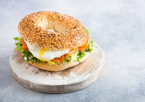 Somon, ricotta ve beyaz mutfak masa arka planda vintage doğrama tahtası üzerinde yumuşak yumurta ile Taze sağlıklı simit sandviç. Sağlıklı diyet gıda. — Stok fotoğraf