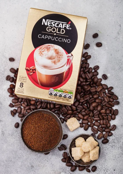 LONDRES, Reino Unido - 15 de agosto de 2019: Pack de Nescafe Gold Cappuccino con granos de café y terrones de azúcar sobre fondo claro de cocina . — Foto de Stock