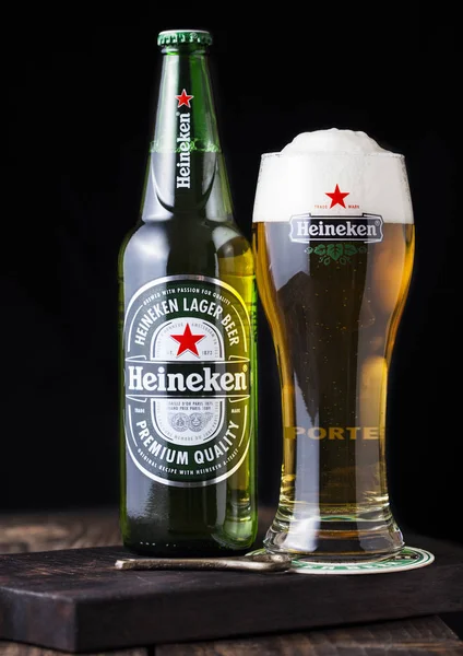 LONDRES, Reino Unido - 27 DE ABRIL DE 2018: Botella y vaso original de cerveza Heineken Lager sobre fondo de madera oscura . —  Fotos de Stock