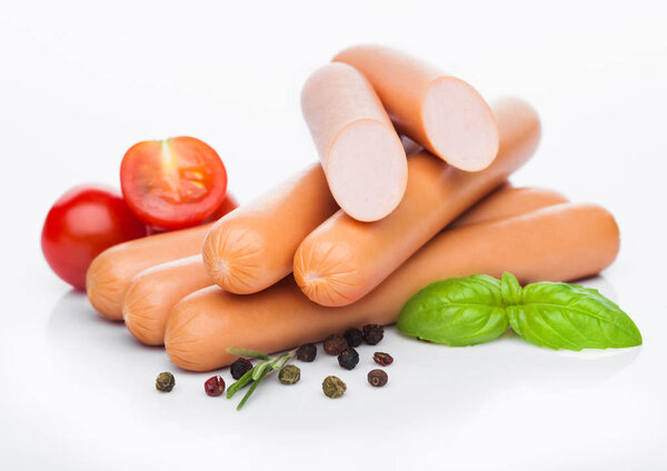 Классические колбасы из свинины с перцем и базиликом и помидорами черри на белом фоне
. 