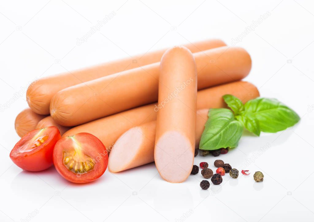 Classic boiled meat pork sausages with pepper and basil and cherry tomatoes on white background. 