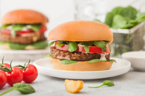 Burger bebas daging vegetarian yang sehat di piring keramik bundar dengan sayuran dan bayam di latar belakang meja yang ringan dengan tomat ceri . — Stok Foto