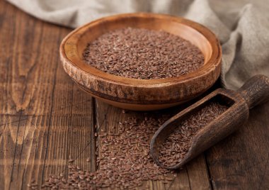 Tahta kapta doğal organik keten tohumu tohumu ve tahta arka planda kaşık. Sağlıklı Omega 3 ürünü.