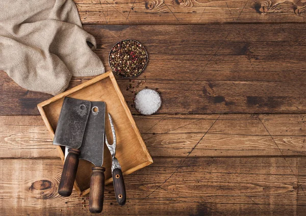 Escotillas vintage para carne en caja de madera con sal y pimienta sobre fondo de mesa de madera con toalla de lino y tenedor. Vista superior — Foto de Stock