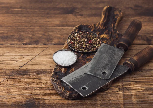 Escotillas vintage para carne sobre tabla de cortar de madera con sal y pimienta sobre fondo de mesa de madera . — Foto de Stock