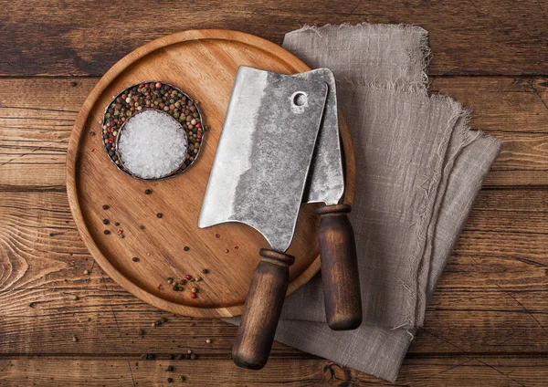 Escotillas vintage para carne en plato redondo de madera con sal y pimienta sobre fondo de mesa de madera con toalla de lino . — Foto de Stock
