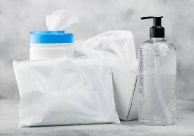 El dezenfekte edici plastik mendilli plastik konteynır ve arka planda ıslak mendil paketi olan mendil kutusu. Tüm virüslerden en iyi korunma