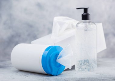 Beyaz arka planda plastik mendiller, el dezenfektanı plastik kaplar ve bir kutu mendil. Tüm virüslerden en iyi korunma.