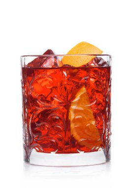 Kristal bardakta Negroni Kokteyli. Buz küpleri ve beyaz arka planda portakal dilimleri.