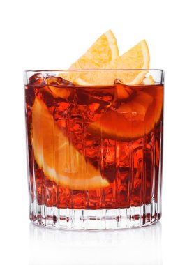 Kristal bardakta Negroni Kokteyli. Buz küpleri ve beyaz arka planda portakal dilimleri.