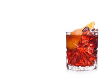 Kristal bardakta Negroni Kokteyli, buz küpleri ve beyaz arka planda portakal dilimleri. Metin için boşluk