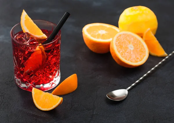 Negroni Koktél Kristálypohárban Narancsszelettel Friss Nyers Naranccsal Kanállal Fekete Háttéren — Stock Fotó