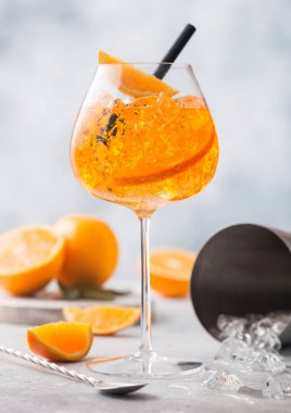 Portakallı aperol spreyi, bar kaşığı ve arka planda kokteyl karışımı. Buz küpleri ve siyah saman.