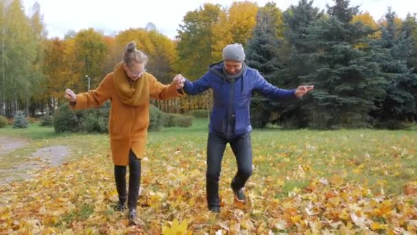 Ο πατέρας διδάσκει κόρη της χορό στο πάρκο φθινόπωρο. Ωστόσο, αυτοί να χαμογελάσει και να γελάσει. Πολλά όμορφα κίτρινο φύλλωμα στο δάσος. — Αρχείο Βίντεο