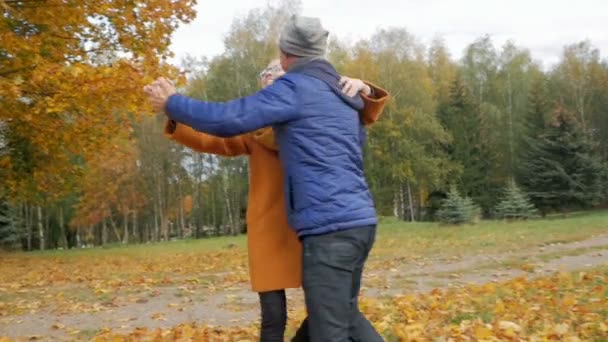 Padre enseña a su hija a bailar en el parque de otoño. Sin embargo, sonríen y ríen. Muchos follaje amarillo hermoso en el bosque . — Vídeos de Stock