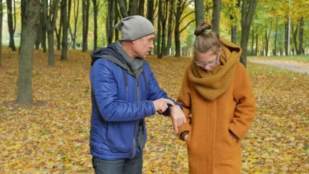 Mio padre insegna danza alla figlia nel parco autunnale. Sorridono e ridono. Molte belle foglie gialle nella foresta . — Video Stock