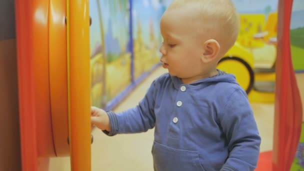 Een jongen speelt in het centrum van de ontspanning van een groot winkelcentrum. Veel interessante onderwijsspelen trekken baby. — Stockvideo