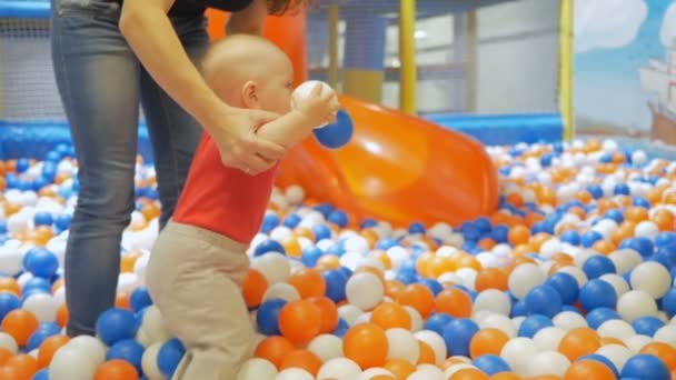En pojke leker i stadens fritid ett stort shoppingcenter. Många intressanta pedagogiska spel locka baby. — Stockvideo