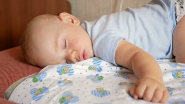 Güzel bebek komik poz bir yatakta uyuyor. Bebek bezi, yaklaşık bir yıl çocuk altında